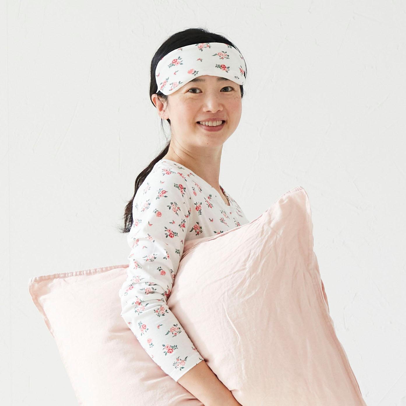 A person wearing pajamas standing next to an ABYGDA mattress.