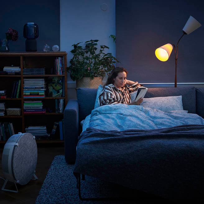 A person's hand holding IKEA smart lighting controller. 