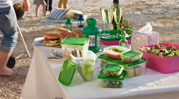 A picnic table at a beach featuring a selection of PRUTA food container storage.