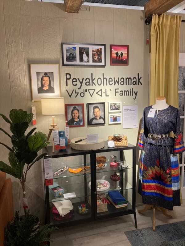 A picture collage wall with a display cabinet in a room setting. 