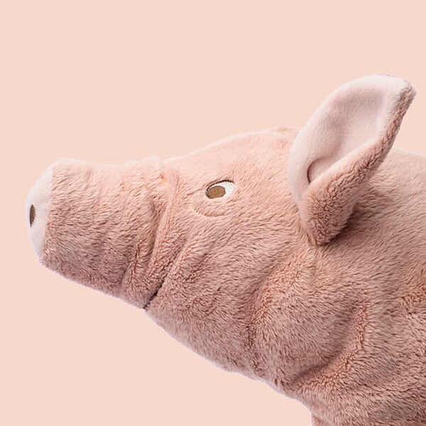 A pig soft toy with a pink background.