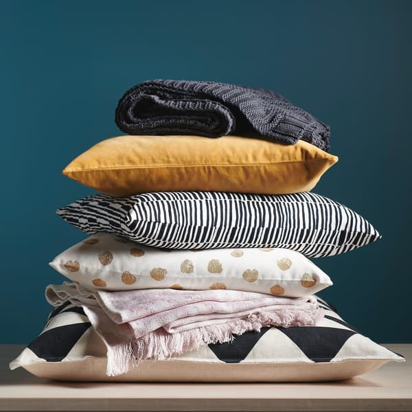A pile of patterned cushions and throws.