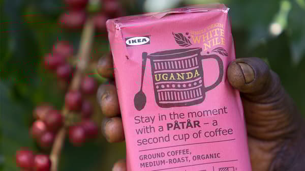 A pink package of PÅTÅR special edition 100% Arabica coffee in the hand of a coffee farmer.