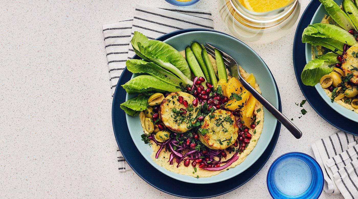 A plate featuring a veggie bowl with cabbage salad & hummus