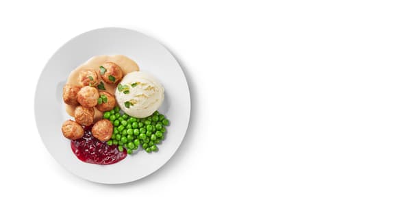 A plate with 12 meatballs, porridge, peas, cranberries and cream sauce.