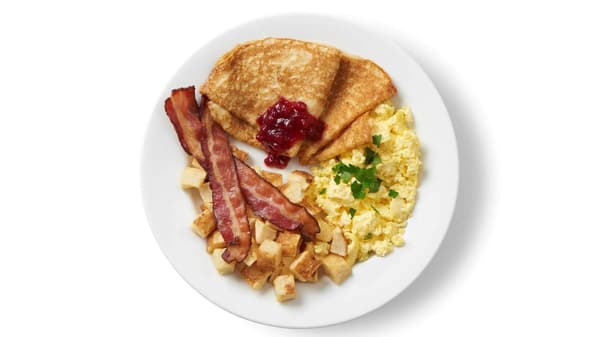 A plate with bacon, potato, scramble egg, pancake and lingon berry jam.
