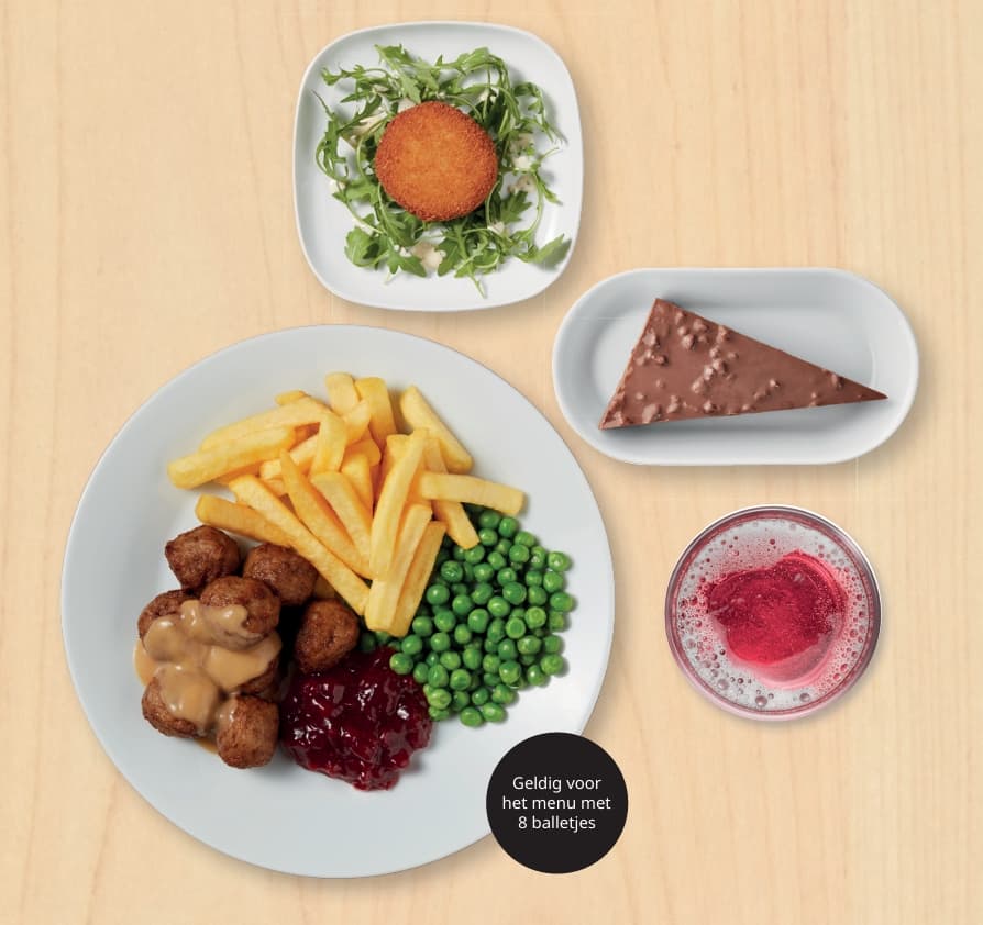 A plate with swedish meatballs, peas and fries. On the side a cheese croquette, daim pie and fruitwater.