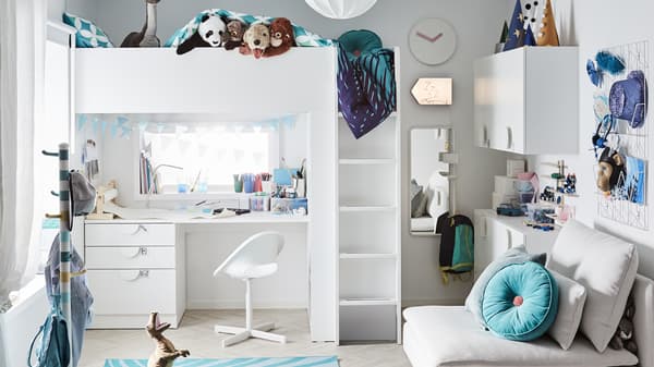 A playful children’s bedroom with a white loft bed and study area below, turquoise accessories and lots of toys.