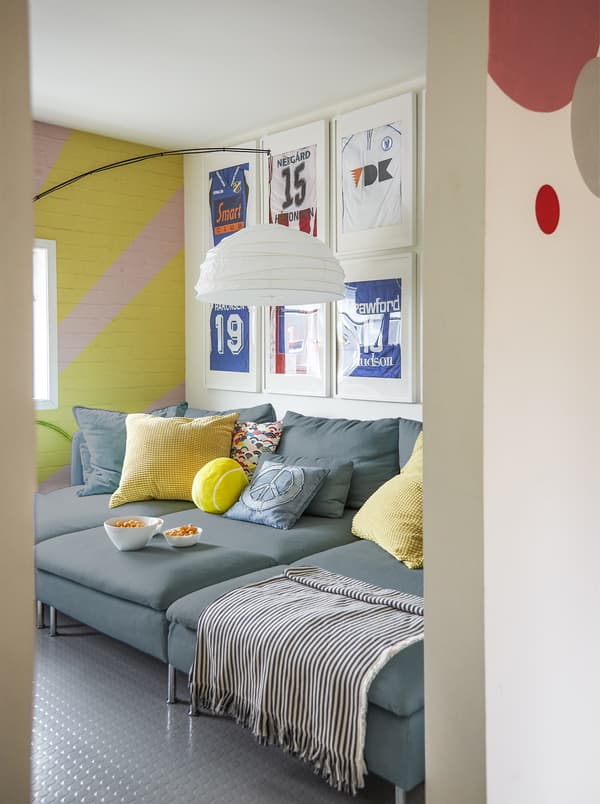 A playroom with large sofa and colourful walls.