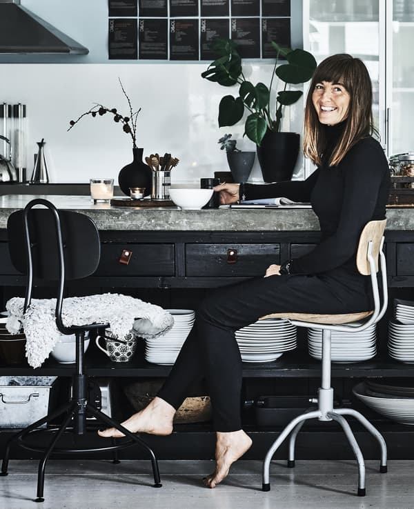 A portrait of Anita drinking tea in her kitchen.