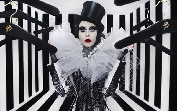 A portrait of Bea Åkerlund posing with clothes hangers.