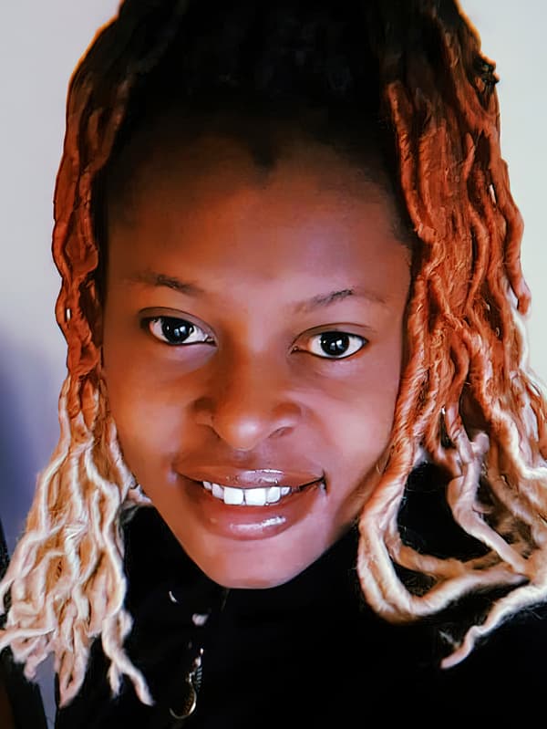 A portrait of Esperance, a Congolese refugee and IKEA Switzerland co-worker, smiling.