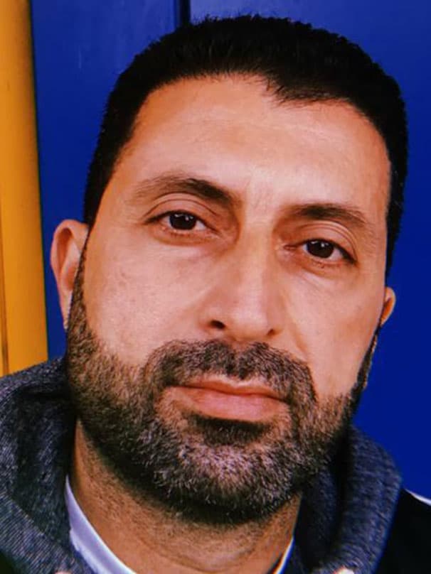 A portrait of Odai, an Iraqi refugee and IKEA Switzerland co-worker, smiling.