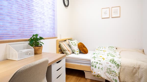 A private room furnished with a desk, chair, and bed.