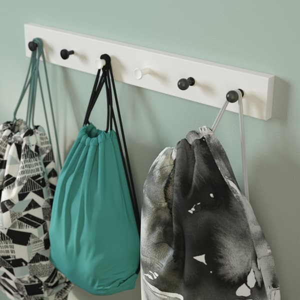A rack with different styled knobs holding children’s gym bags.