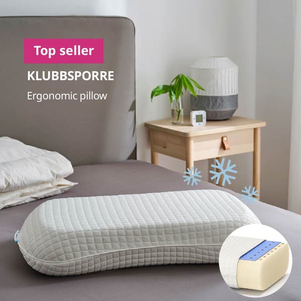A RAMSLÖKSMAL pillow placed on a bed with its cooling side face updwards. 3 light blue snowflakes are present at the top right of the pillow and a circular picture showing the 3 layers of the pillow is seen at the bottom left corner of the picture.