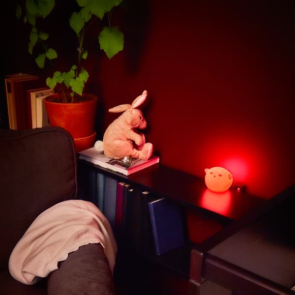 A red night light and a soft toy sit next to an arm chair.