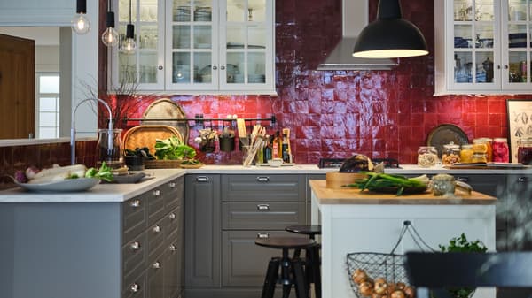A red-tiled kitchen with white wall cabinets, METOD cabinets with MAXIMERA interiors, a white island with a wooden worktop.