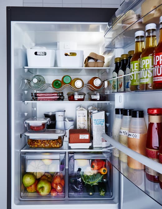 A refrigerator is neatly organized with food sorted neatly into clear or labeled containers.