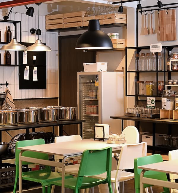 A restaurant setting featuring multiple storage areas and a table with white and green chairs.