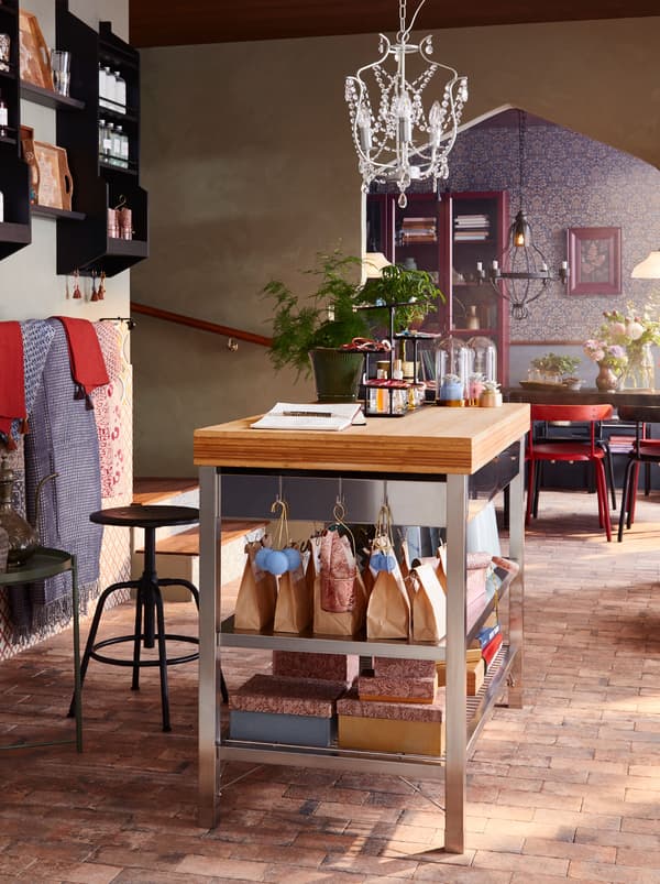 A RIMFORSA workbench and KULLABERG barstool being used as a reception area, with objects for sale displayed on lower shelves.