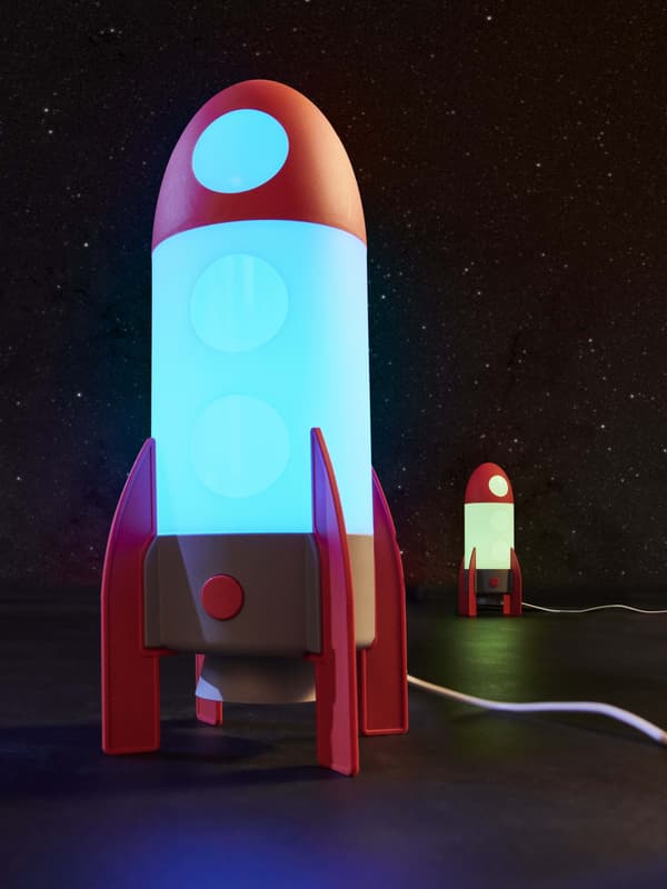 A rocket lamp with a blue light lit in the middle and smaller rocket next to it with a green light lit in it