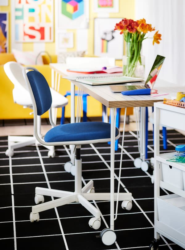 A room filled with a desk, papers and a chair.