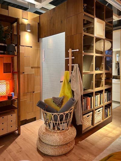 A room set with a wooden interior, a rattan foot bench and a rattan basket.