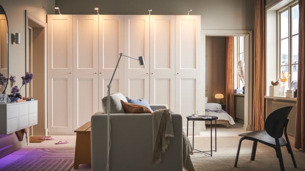 A room with a beige VIMLE 2-seat sofa-bed in the middle and two white PAX/GRIMO wardrobes along the back wall.