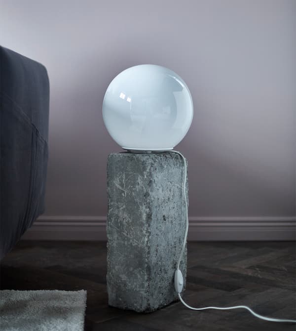 A round table lamp sitting on a rock.