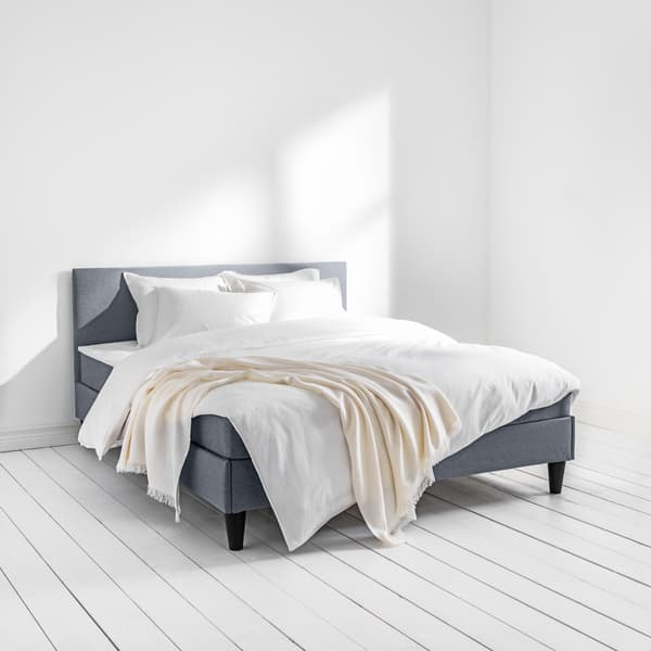 A SÄBÖVIK bed with grey fabric cover around the frame and headboard in the size 160x200 in the bedroom