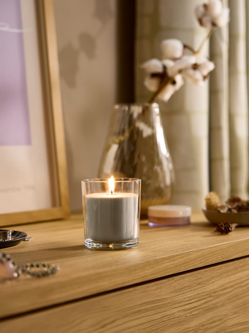 A Sandalwood & patchouli brown LOTSFÅGEL scented candle in glass in the bedroom