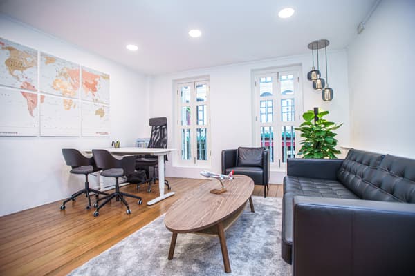 A Scandinavian-inspired office featuring a sofa, coffee table, desk and office chair.