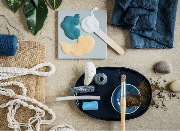 A selection of small home furnishing accessories in neutral hues and blue accents.