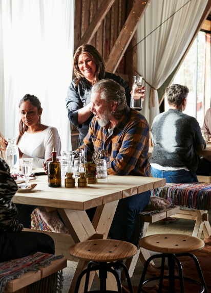 A server bringing water to a table of guests