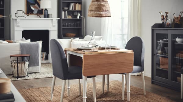 A set DANDERYD drop-leaf table with two DANDERYD chairs stand in the middle of a light, airy living room.