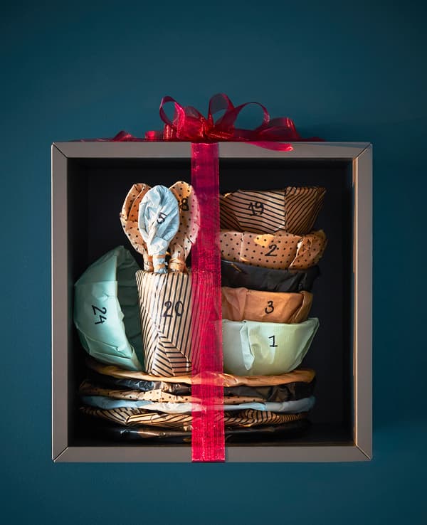 A set of wrapped and numbered dinnerware is wrapped and displayed on a shelf.