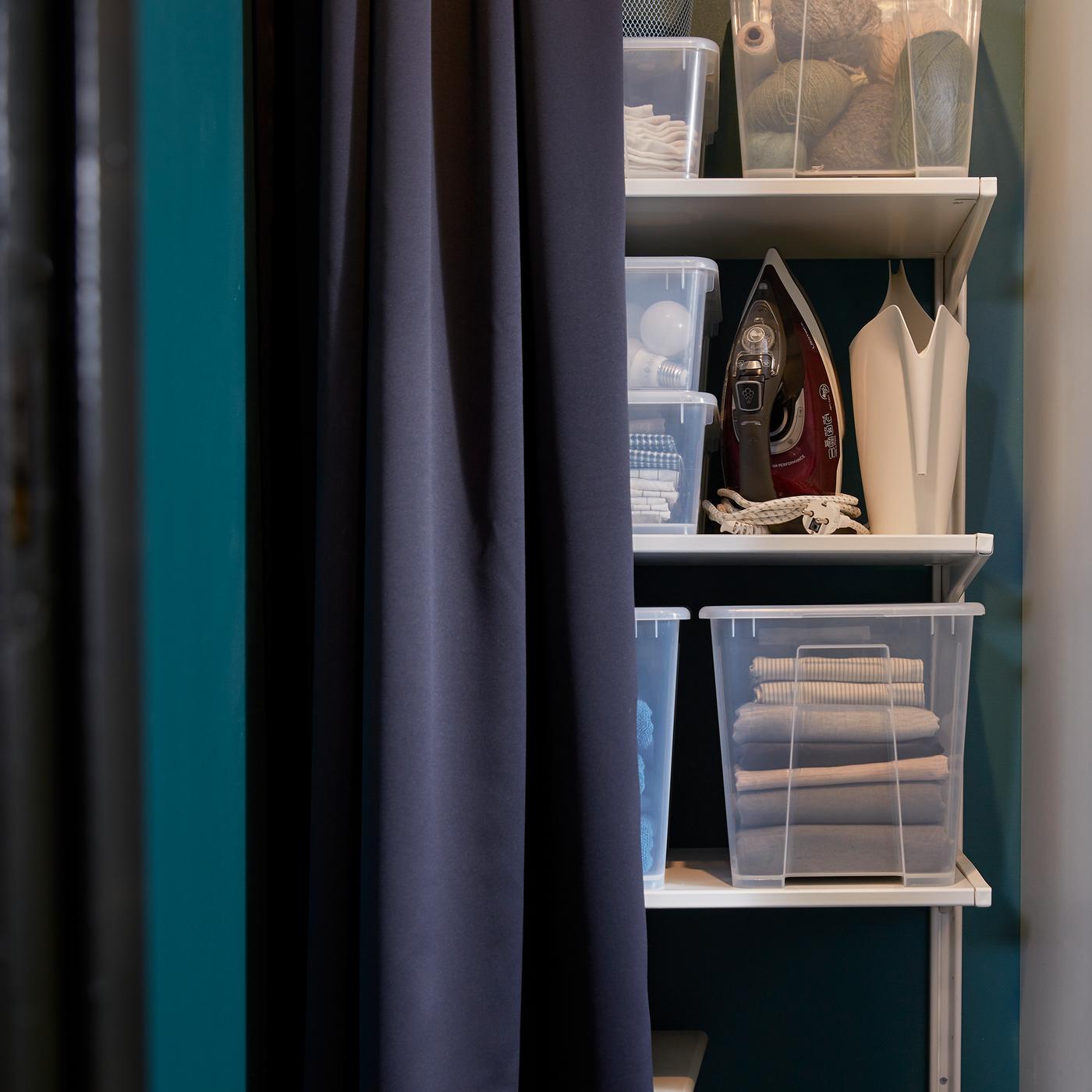  A shelving unit with a number of SAMLA bins and an iron.