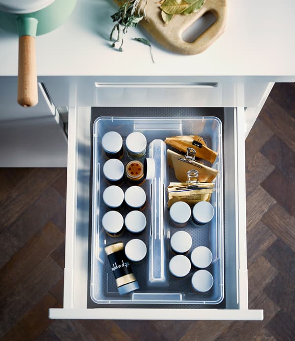 A shot from above of an IKEA SAMLA box filled with jars of herbs and spices in an open drawer.