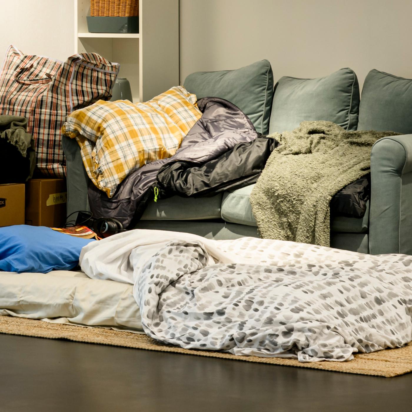 A showcase of a living situation for a mother and her child sleeping on a sofa.