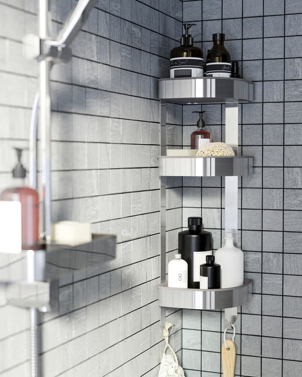 A shower with grey tiles and a corner wall shelf in stainless steel that stores shower gels, shampoos and more.