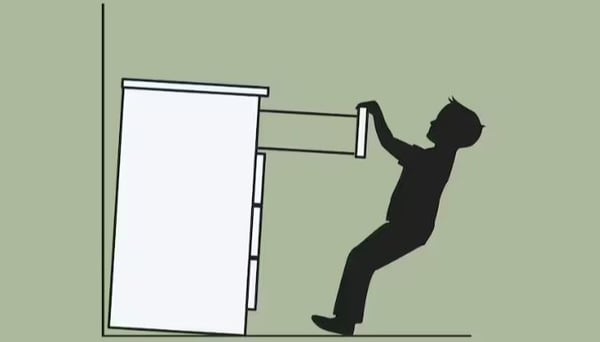 A sketch of a chest of drawers, which is not secured to a wall, tipping over on a child who is pulling on a drawer.