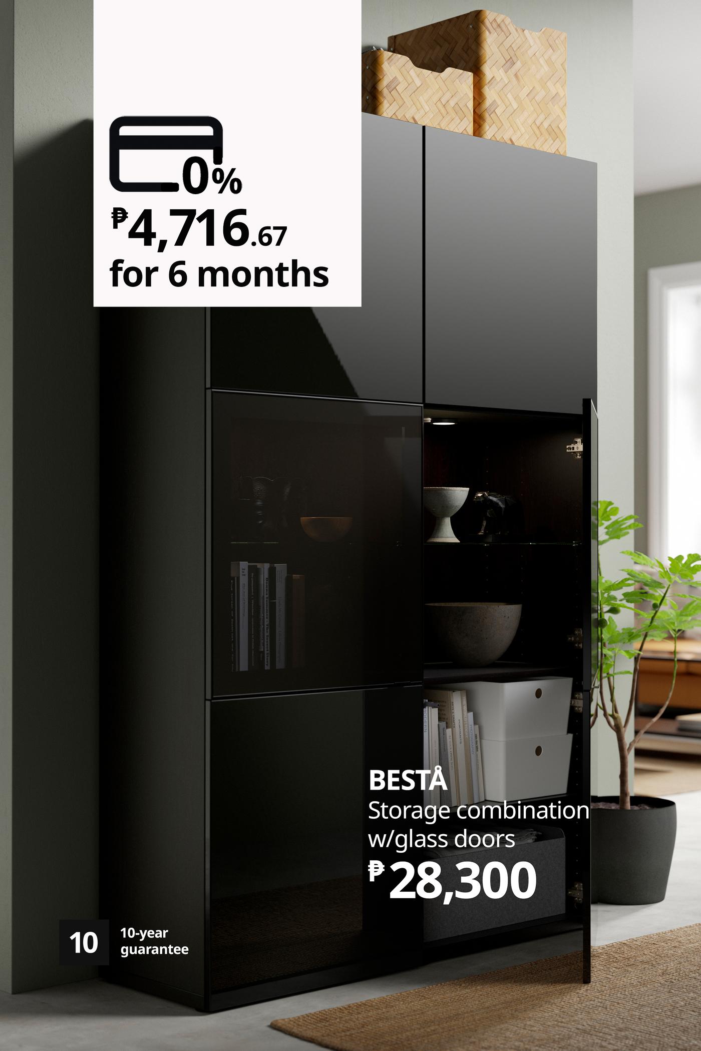 A sleek black BESTÅ storage unit with glass doors stands in a modern room; ad shows ₱28,300 price and 0% financing for six months.