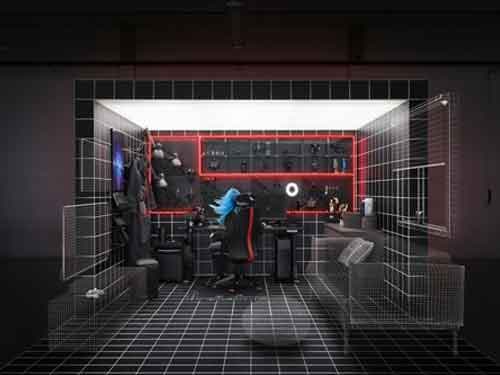A sleek, dark room with a person sitting with blue hair and red lights on the wall surrounding game accessories.