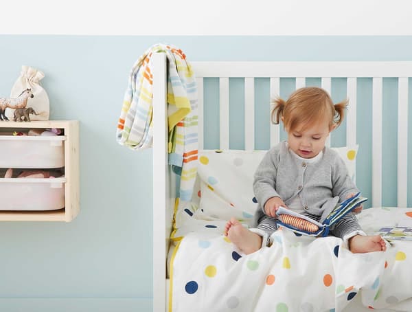 A small child reading a book in bed.