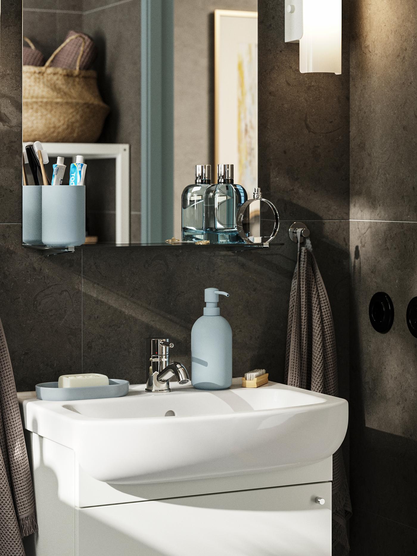 A small, dark brown spa bathroom with a white NYSJÖN wash-basin cabinet with one door, and a mirror above it.