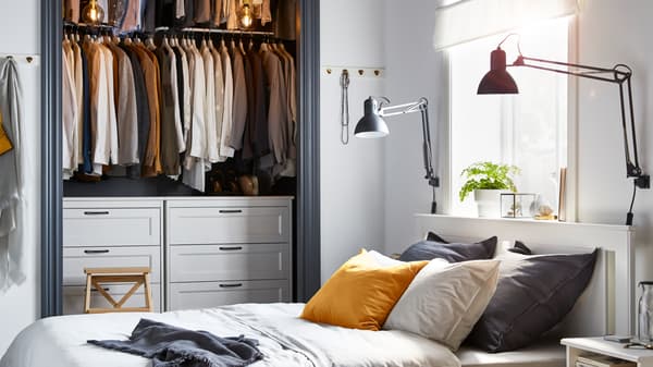 A small grey and white bedroom, with an open closet and IKEA SONGESAND white bed frame.