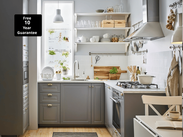 A small grey and white kitchen with BODBYN grey kitchen drawer fronts and brass-colour ENERYDA knobs and cup handles.
