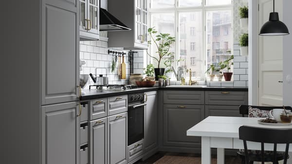 A small kitchen with grey kitchen cabinets, a black mineral-effect worktop, a white sink with a visible front and a gas hob.