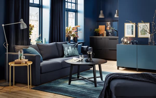 A small modern dark blue living room with black-blue VIMLE three-seater sofa and black round coffee table.